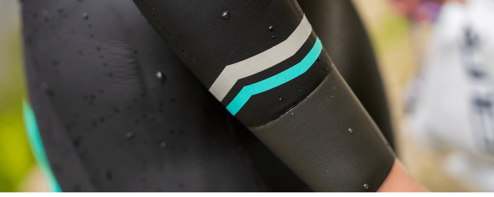 Close up of a neoprene wetsuit sleeve with turquoise and silver stripe accents