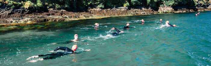 a group of people are swimming in along the bantham swoosh route