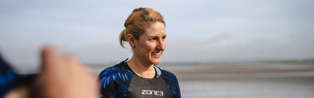 Coach Gemma Dobson is standing on the beach wearing ZONE3 swimskin