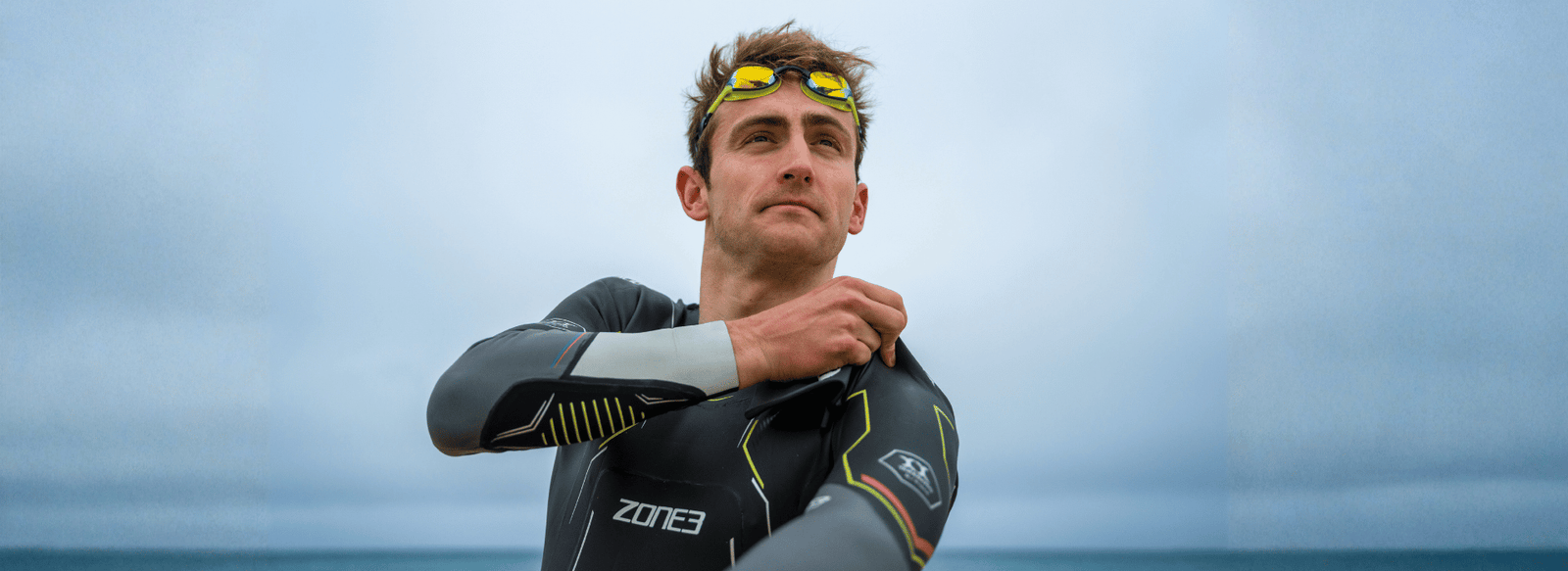 pro triathlete kieran lindars is pulling up his Zone3 wetsuit around his shoulders