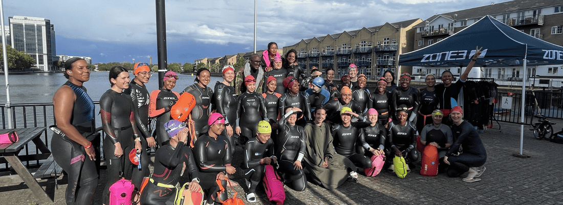 a group of women in tri are all wearing their zone3 wetsuits, next to the docklands sailing and watersports open water swim venue 