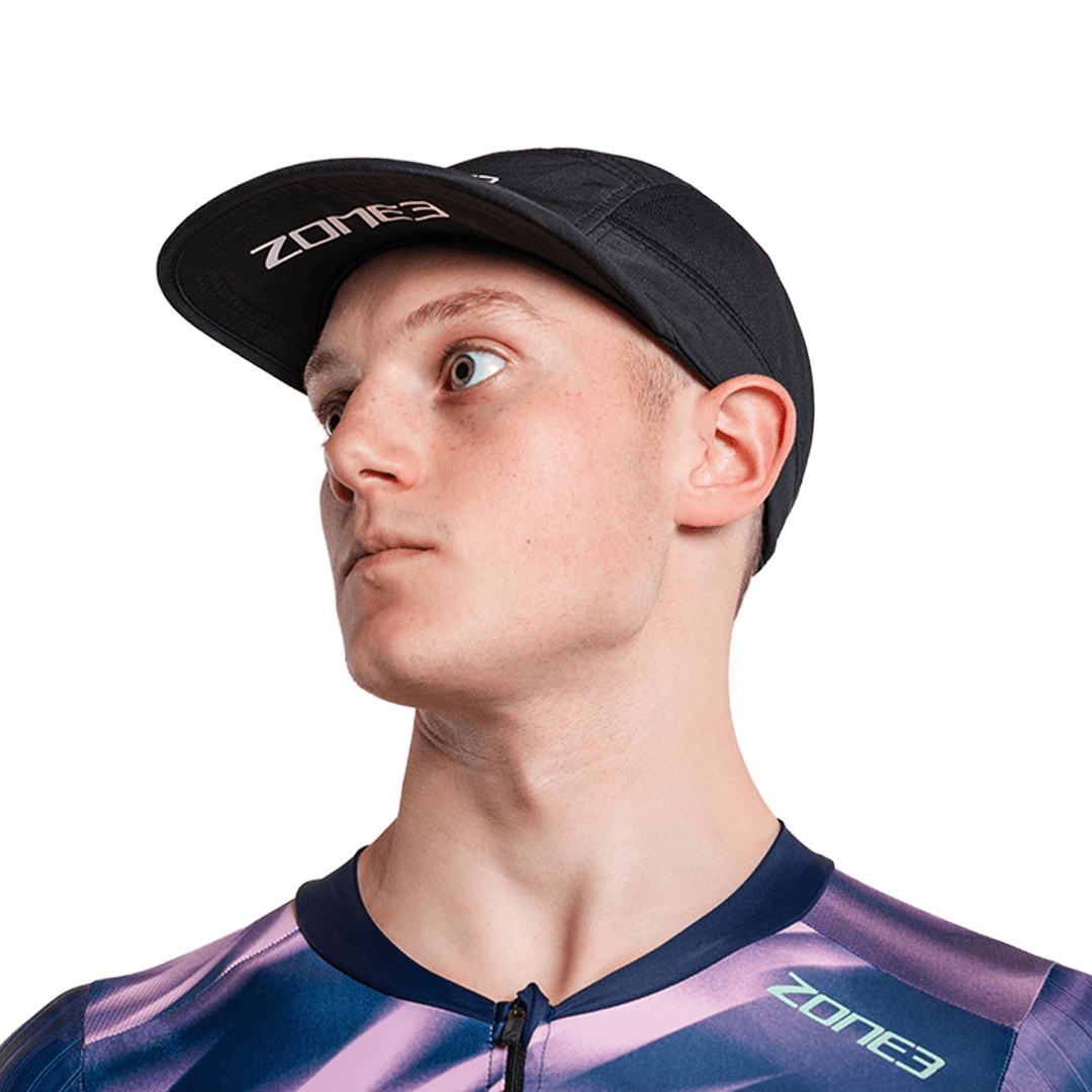 Person, die eine schwarze 5-Panel-Laufkappe mit Zone3-Logo auf weißem Hintergrund trägt