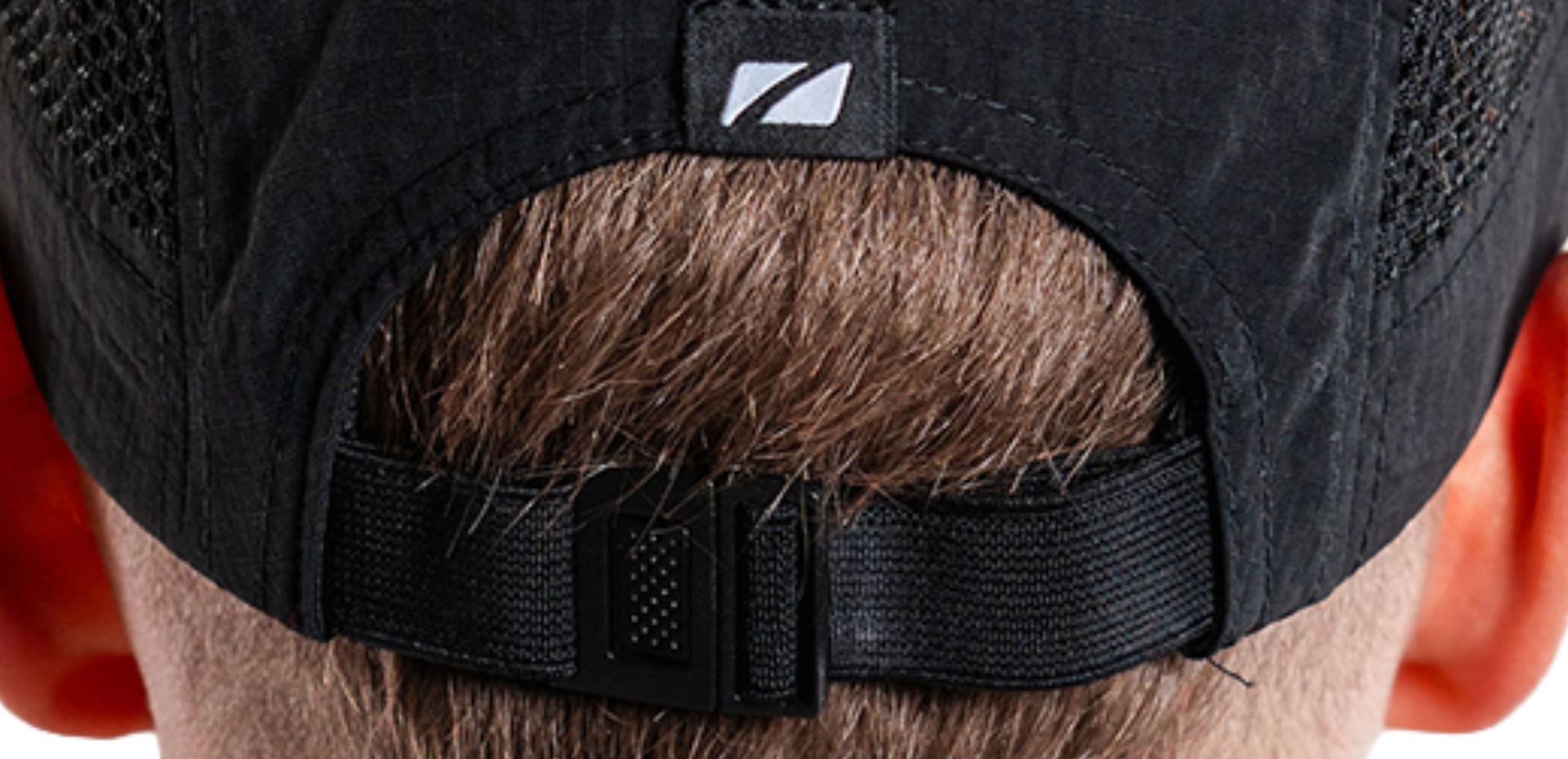 Close-up of a black mesh running cap with zone3 logo on a person's head.