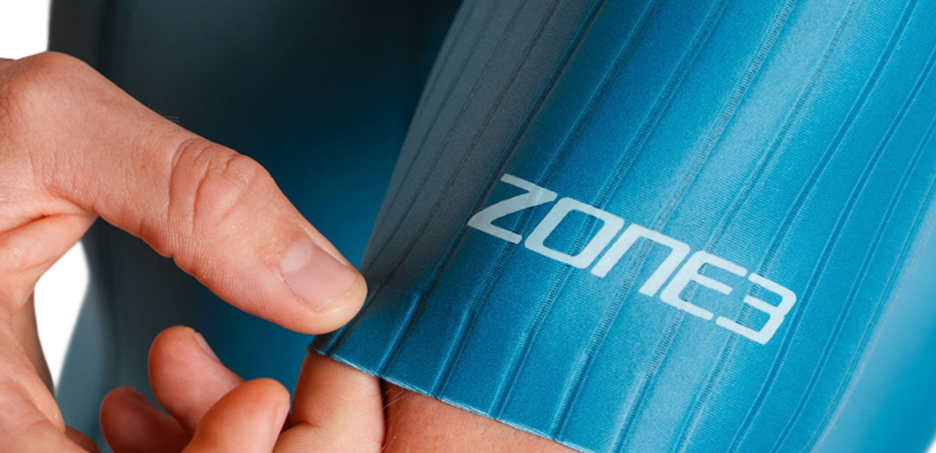 Person wearing tealtrisuit with 'Zone3' branding, pointing to the armband.