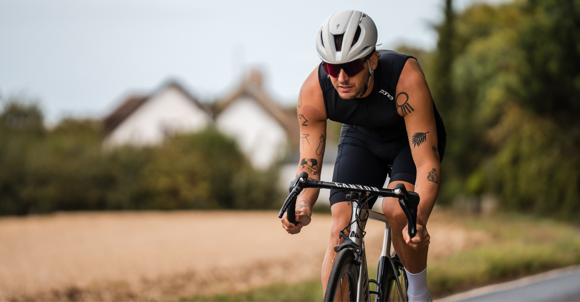 Person cycling wearing zone3 black activate+ sleeveless trisuit on a blurred background