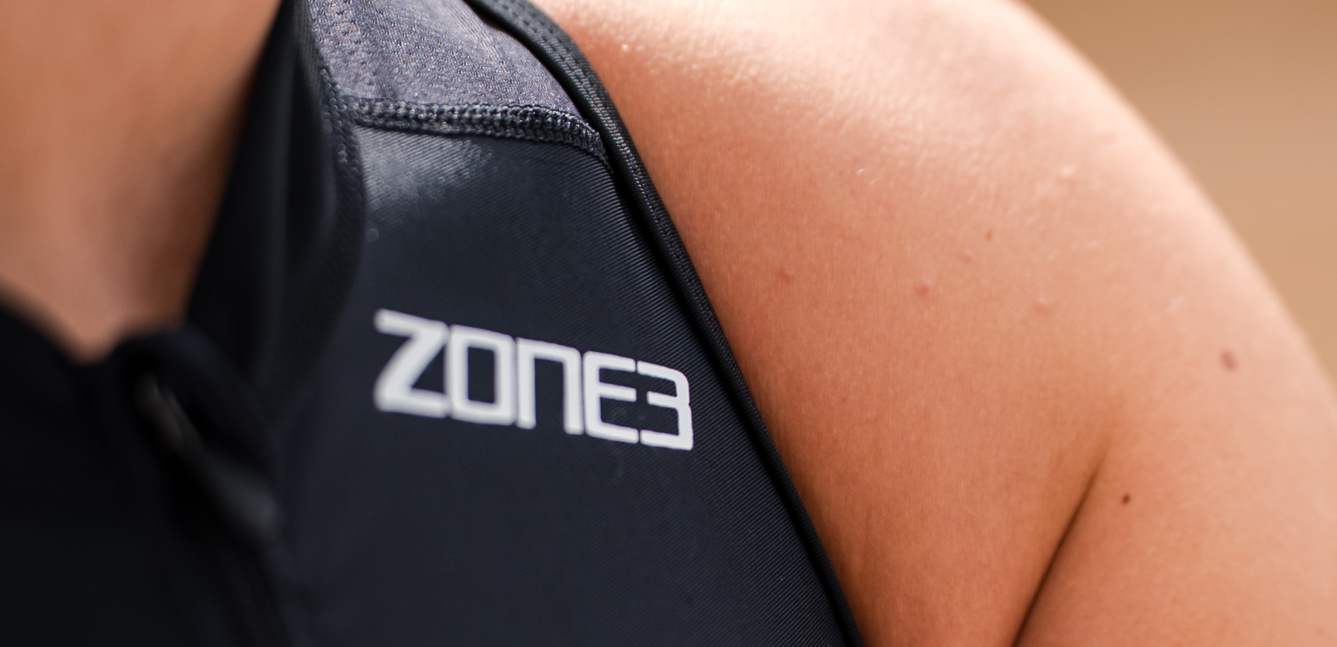Close up of zone3 black activate+ sleeveless trisuit on a blurred background