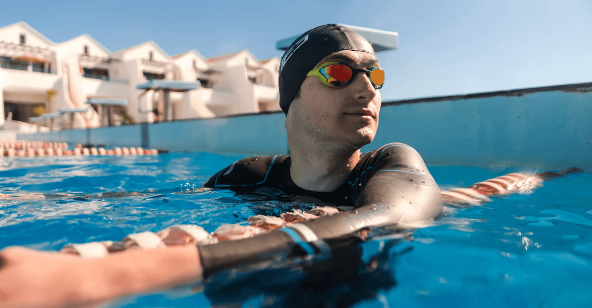 Athlete chilling above water in the pool wearing the Zone3 advance wetsuit and goggles. 