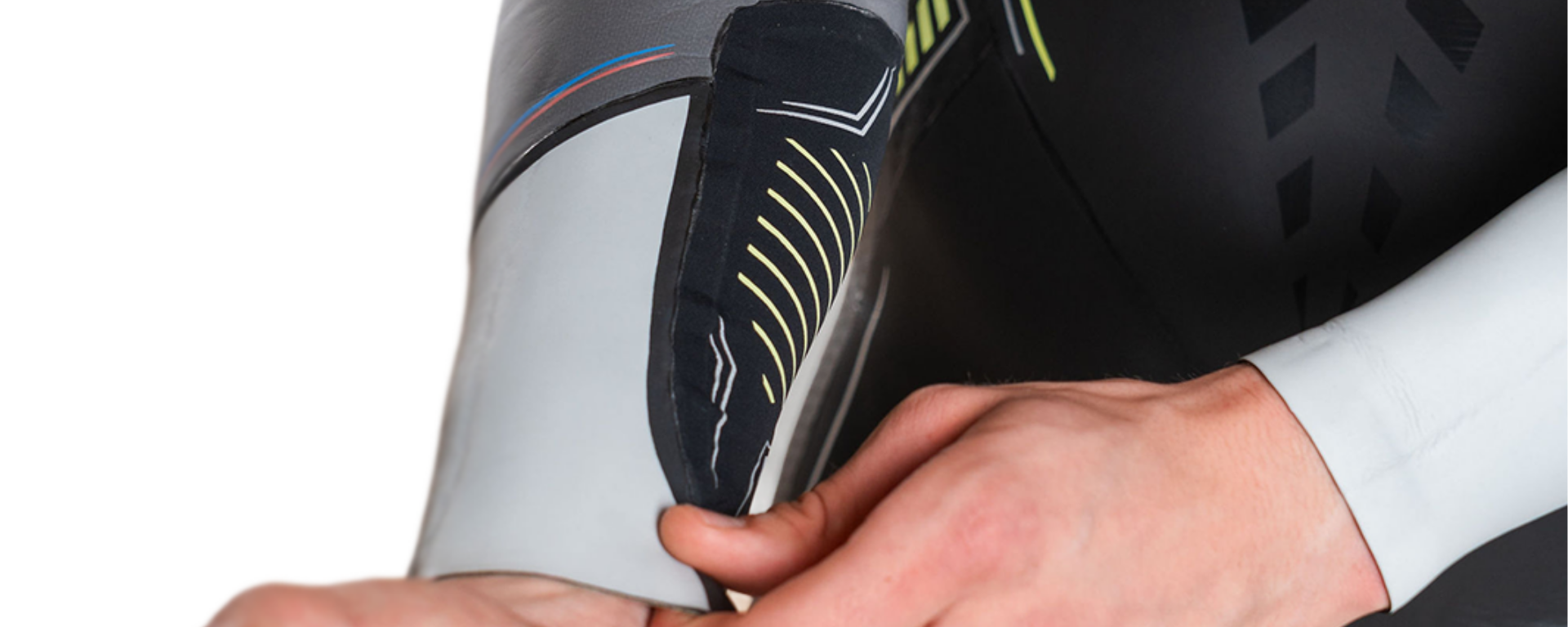 Close-up of a person wearing a black and gray sneaker with a white background