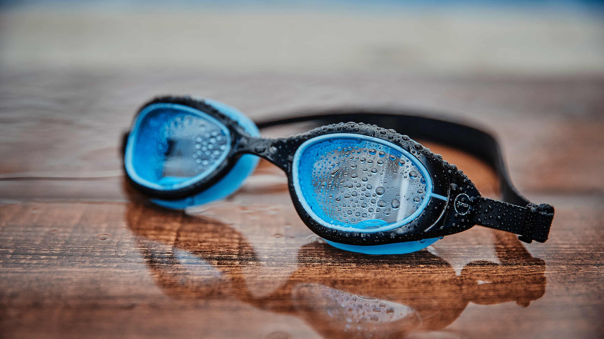 The black blue Attack goggles on wooden floor. 