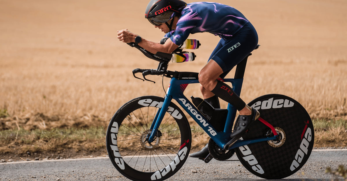 Athlete wearing Zone3 Triwear and Calf_sleeves__Aeroforce-X_II while cycling. 