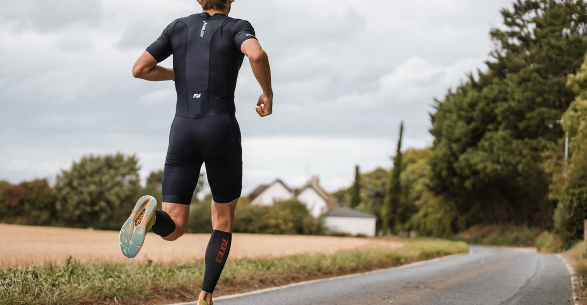 Athlete running wearing Zone3 triwear in black and Calf_sleeves__Aeroforce-X_II