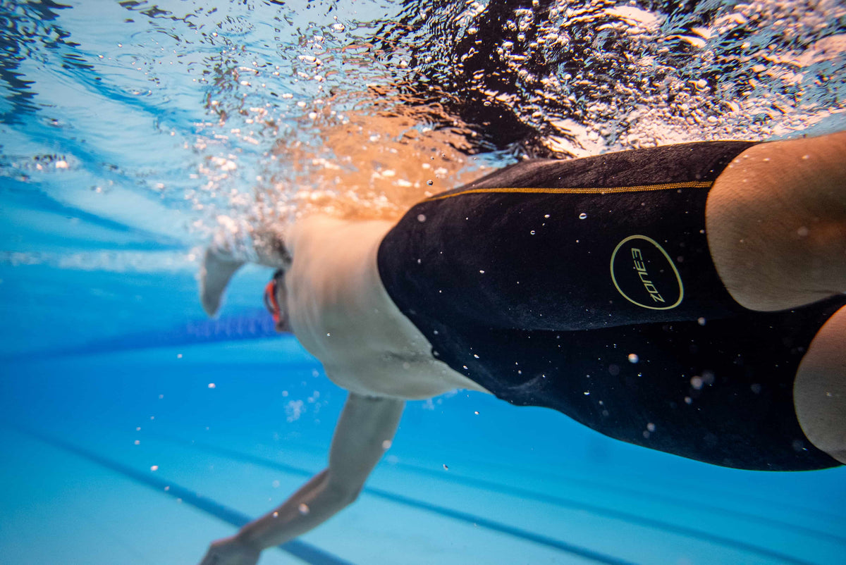 Athlete wearing the Zone3 FINA Approved Men's Performance Gold Jammers in the pool. 