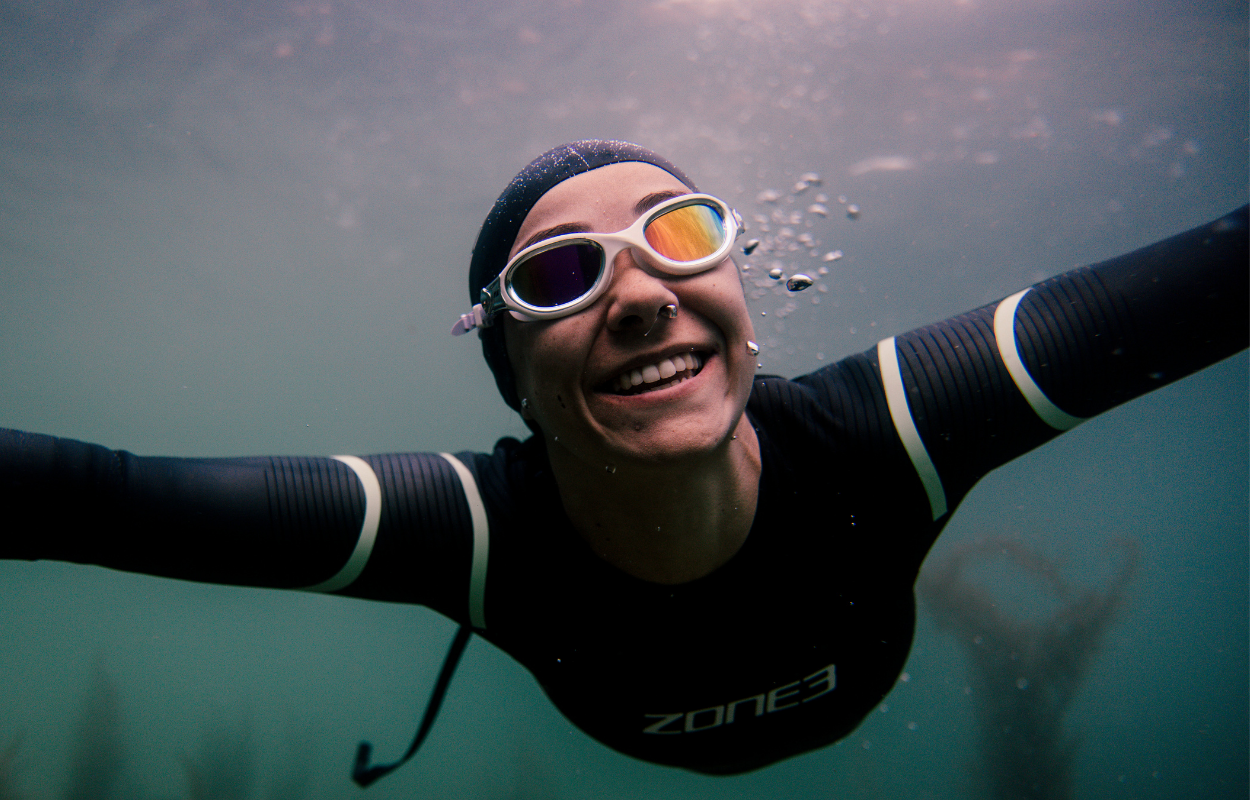 Person wearing a ZONE3 Glide wetsuit and Venator-X goggles underwater