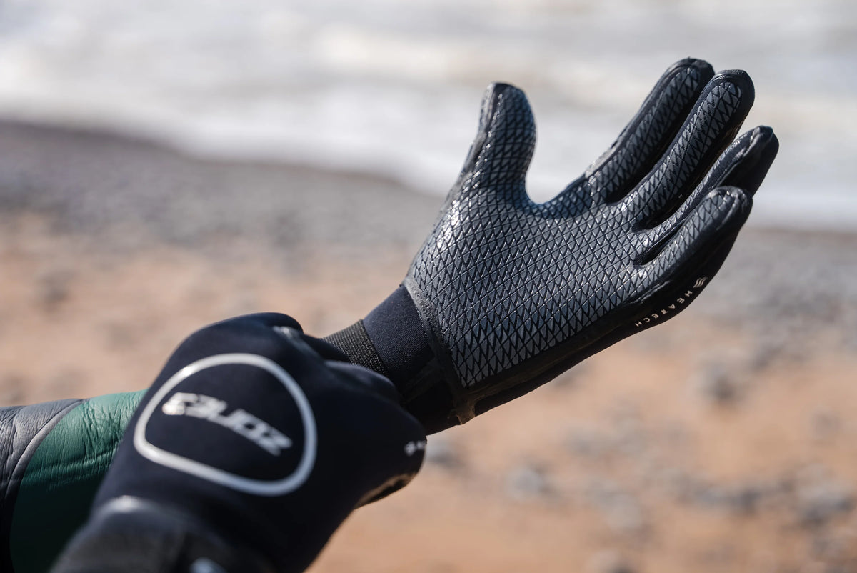 Close up of the Zone3 Heat Tech Swim Gloves while at the beach. 