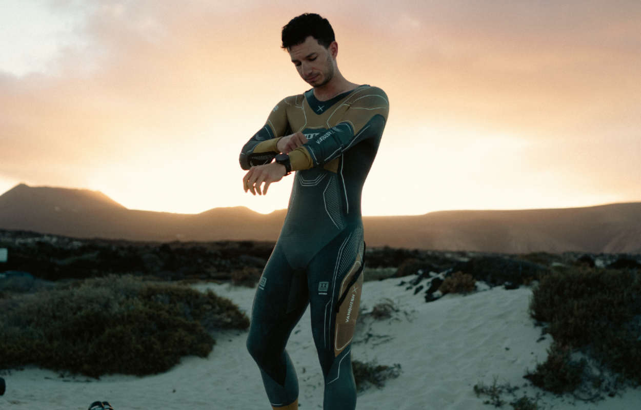 Male wearing a ZONE3 Vanquish-X Limited Edition. He is adjusting the arms of the wetsuit.
