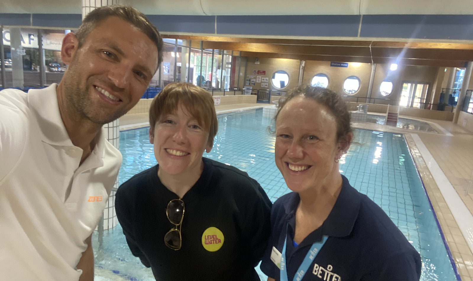 Photo of Founder James Lock with two Level Water ambassadors. Behind them is a swimming pool.