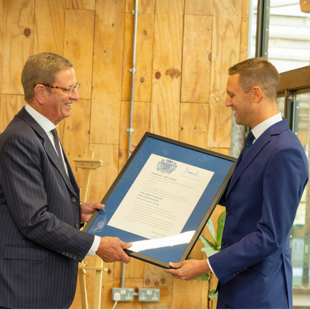 Lord lieutenant handing James Lock a framed certificate for the King's Award