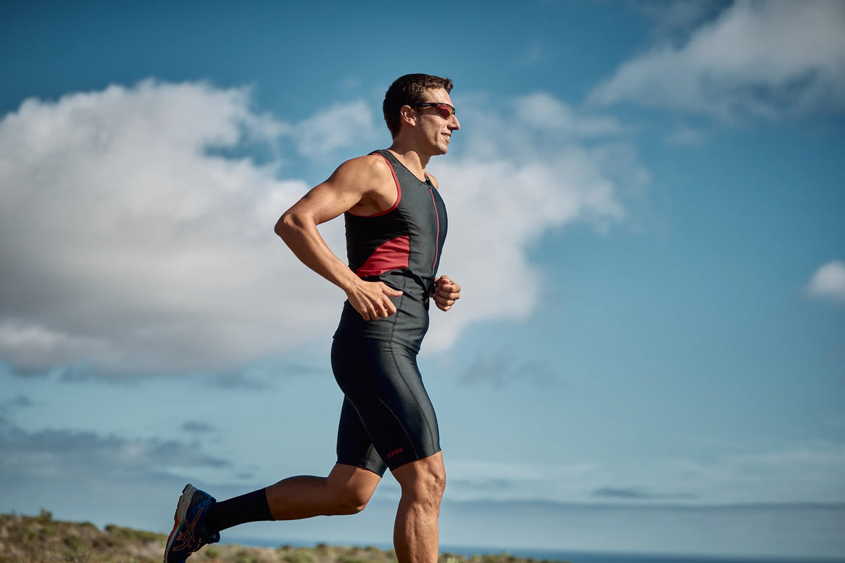Man running outdoors in Zone3 triwear Activate a clear sky in the background