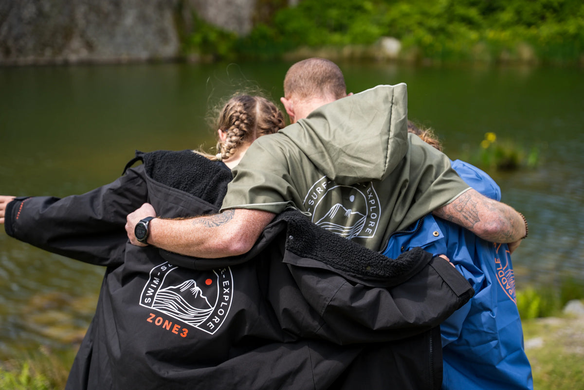 Three people hugging outdoors by a body of water, Microfibre Changing Robe.