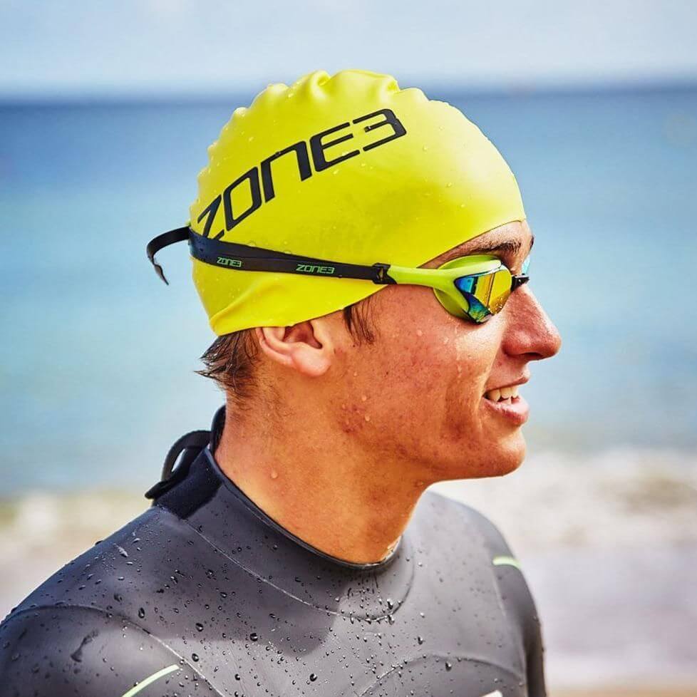 close of an Athlete wearing the Zone3 swim cap, goggles and wetsuit at the beach. 