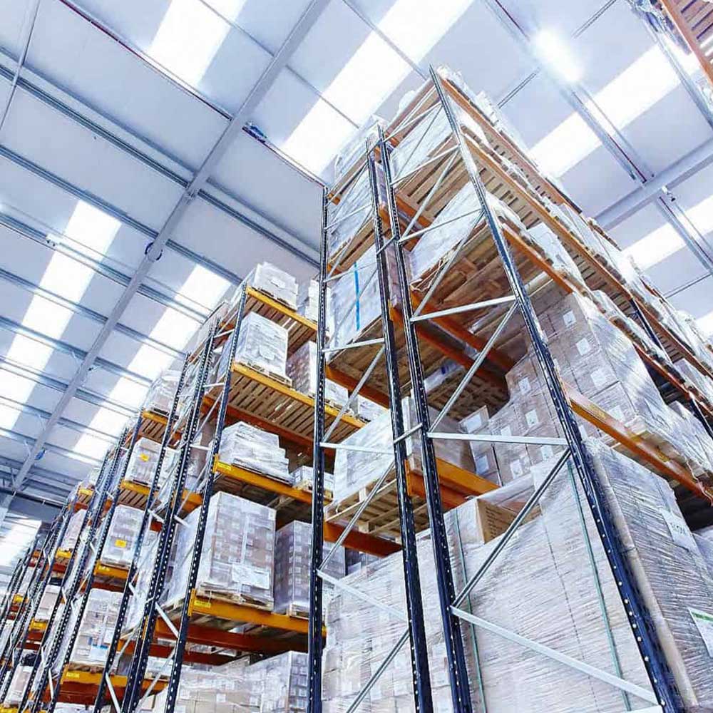 An image showing a warehouse. There are stacks of sealed products reaching the ceiling.