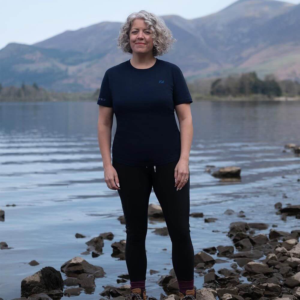 A Women standing by a lake wearing a Zone3 Thirlmere Short Sleeve_T-Shirt in Navy.