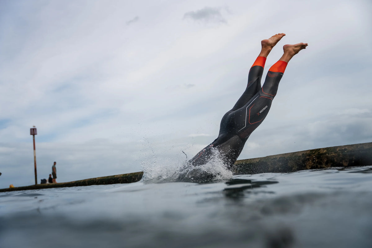 athlete diving into open water wearing the Zone3 Vanquish-X