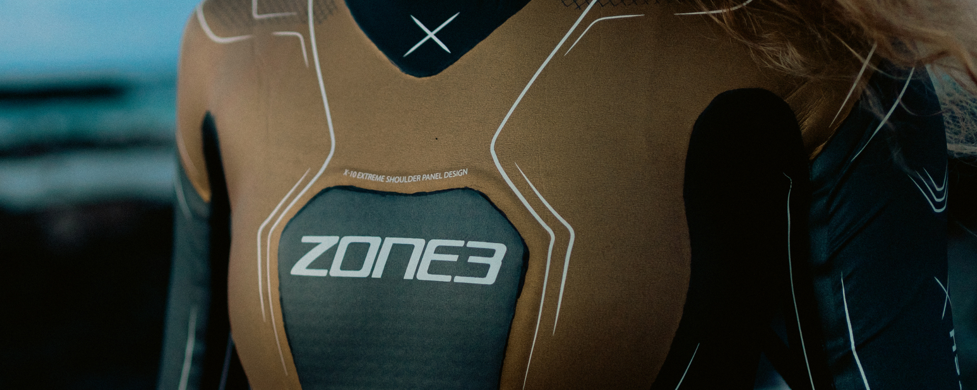 close up of the front facing Limited Edition Vanquish- X wetsuit. showing the black and Gold detailing. 