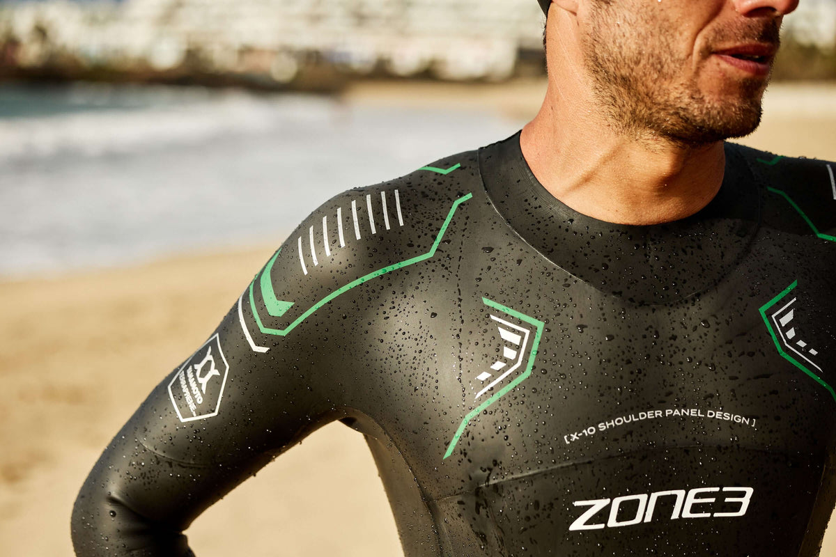 Person wearing a Zone3 wetsuit on a beach