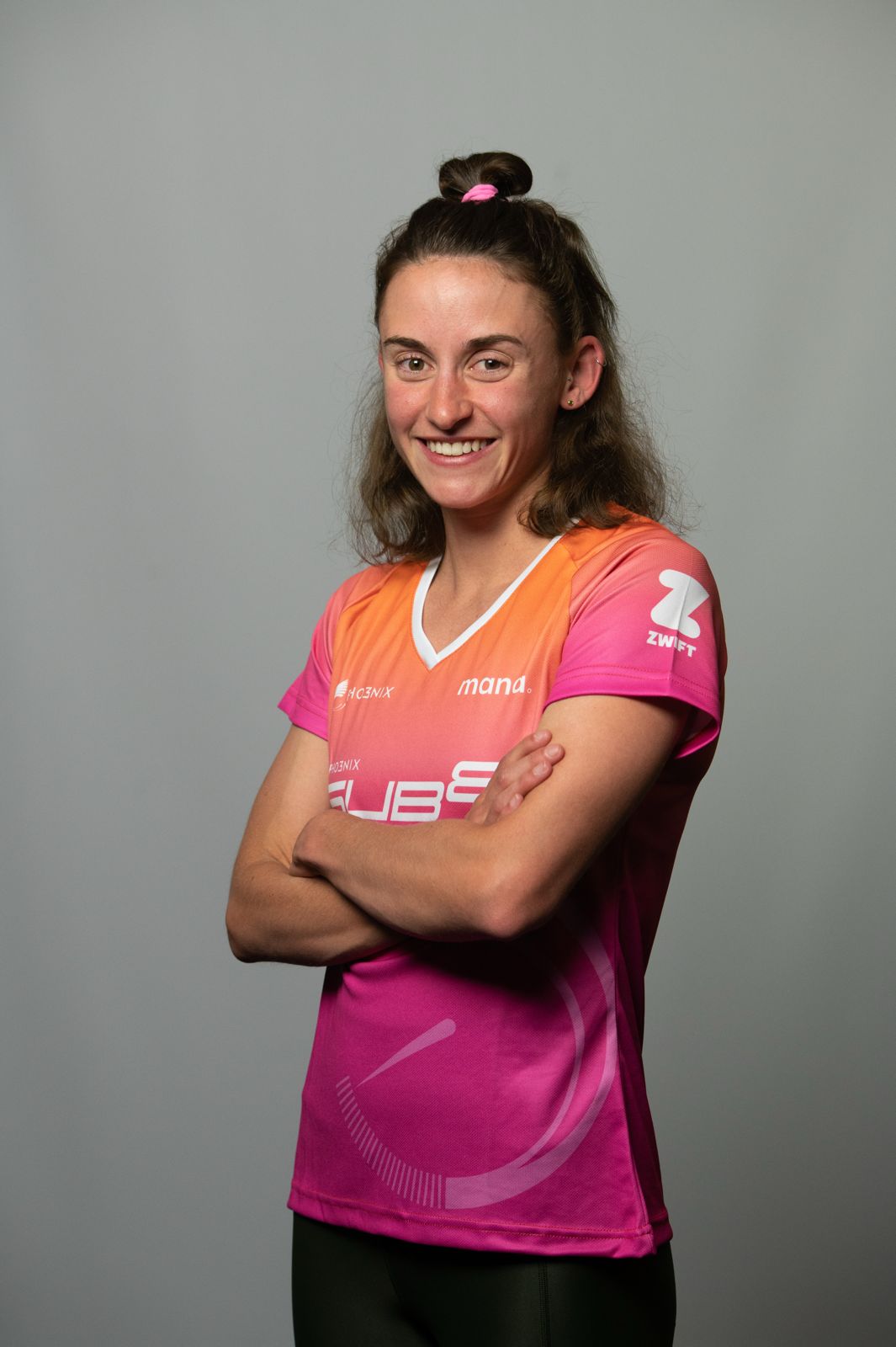 Woman wearing a pink sports jersey with visible branding on a gray background