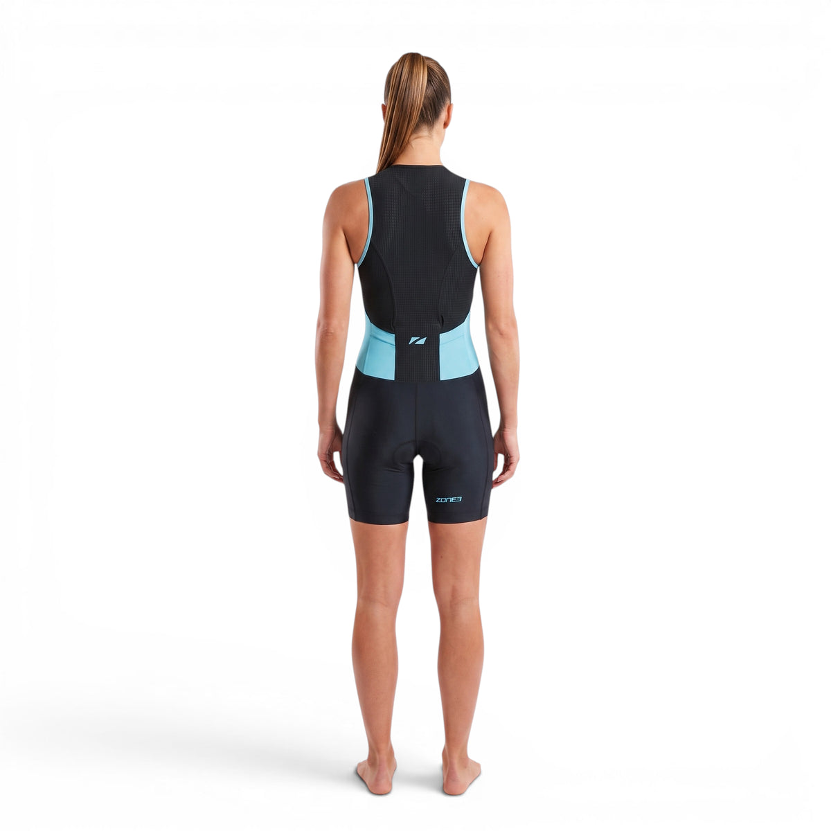 A woman wearing the Zone3 Activate trisuit in black with blue detailing. showing the trisuit from the back side on a white background.