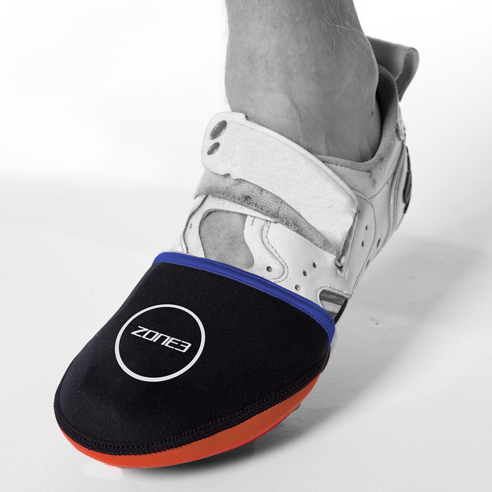 Foot in a cycling shoe wearing a black neoprene toe cap warmer with blue trim