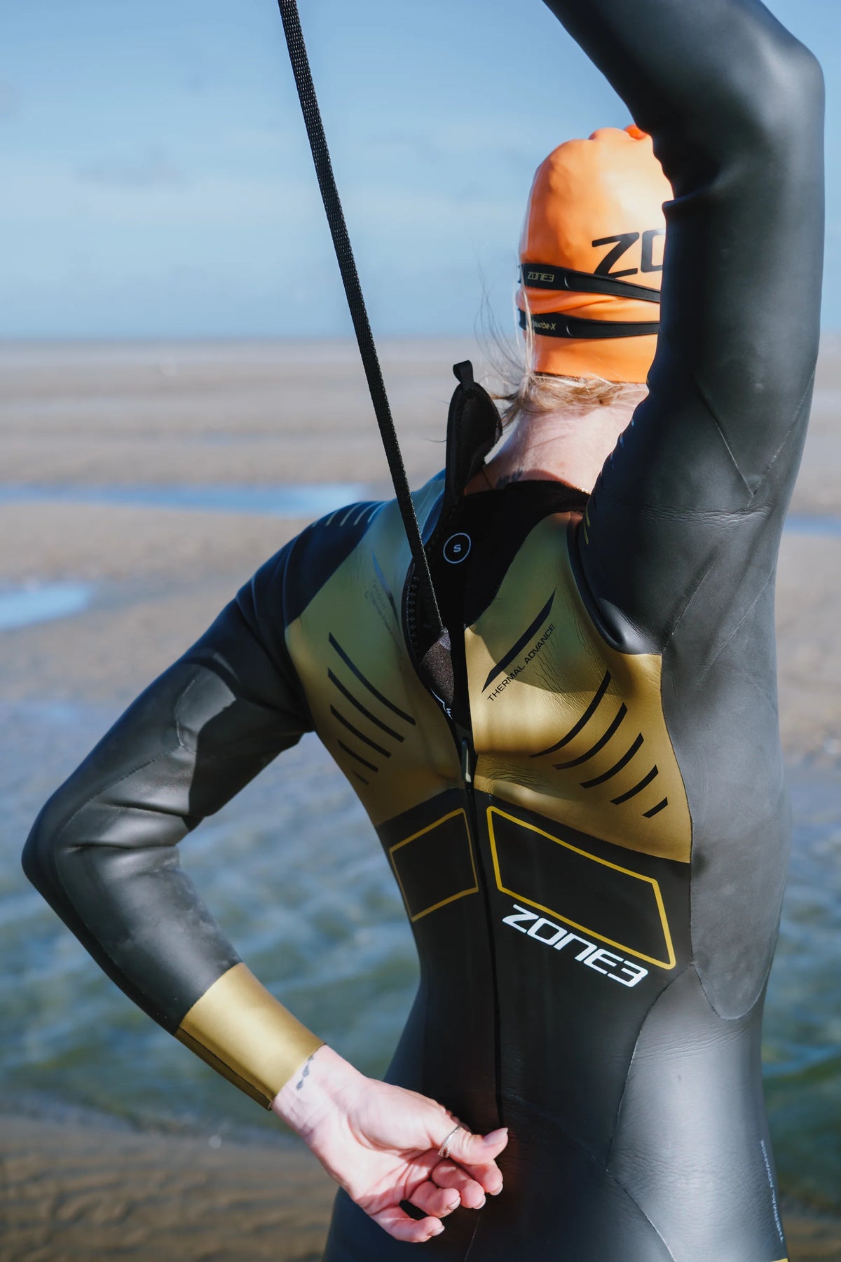 close up of an the back of the Zone3 Thermal Advance wetsuit being zipped up before the swim.