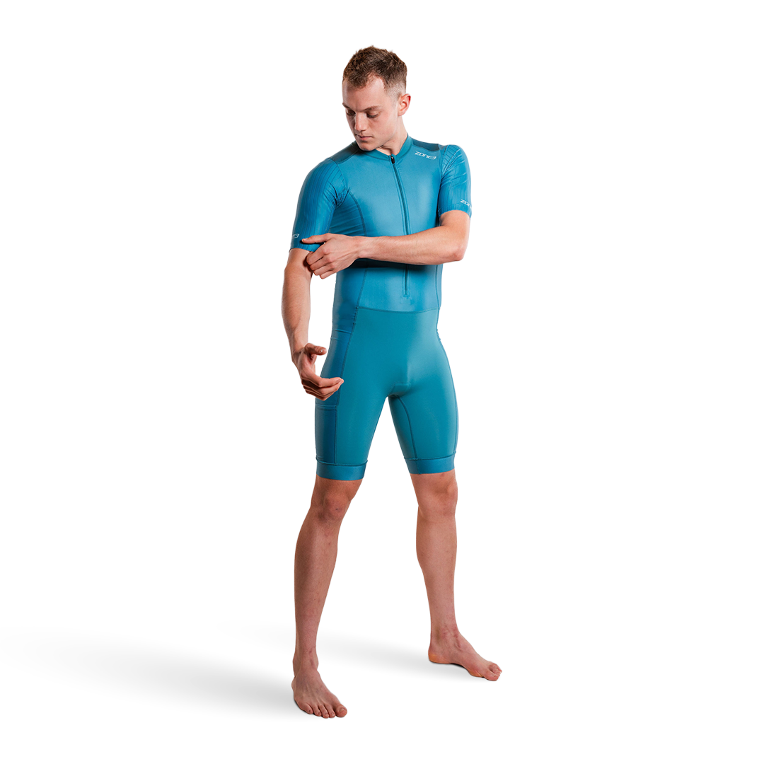 Person, die einen blaugrünen Trisuit auf weißem Hintergrund trägt