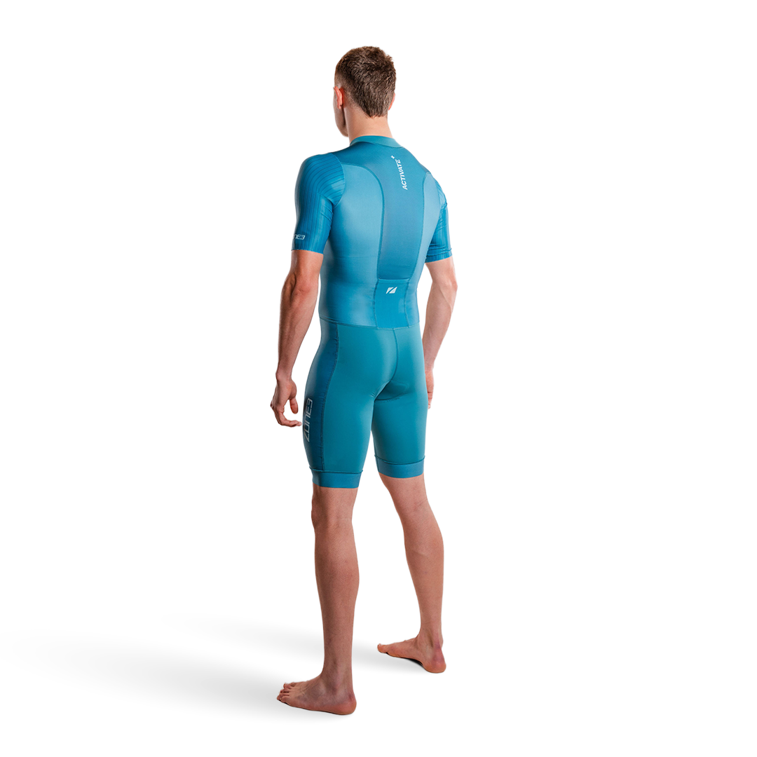 Person, die einen blaugrünen Trisuit auf weißem Hintergrund trägt