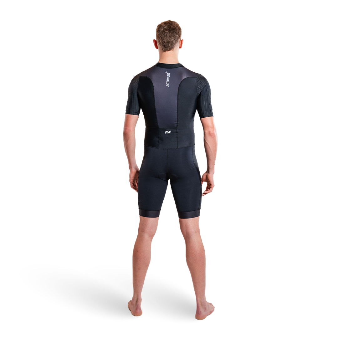 Person trägt einen schwarzen Trisuit auf weißem Hintergrund