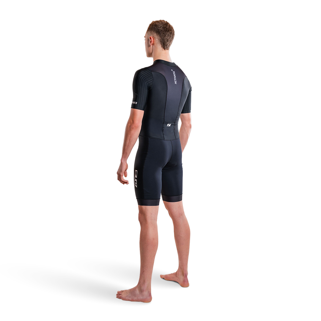 Person trägt einen schwarzen Trisuit auf weißem Hintergrund