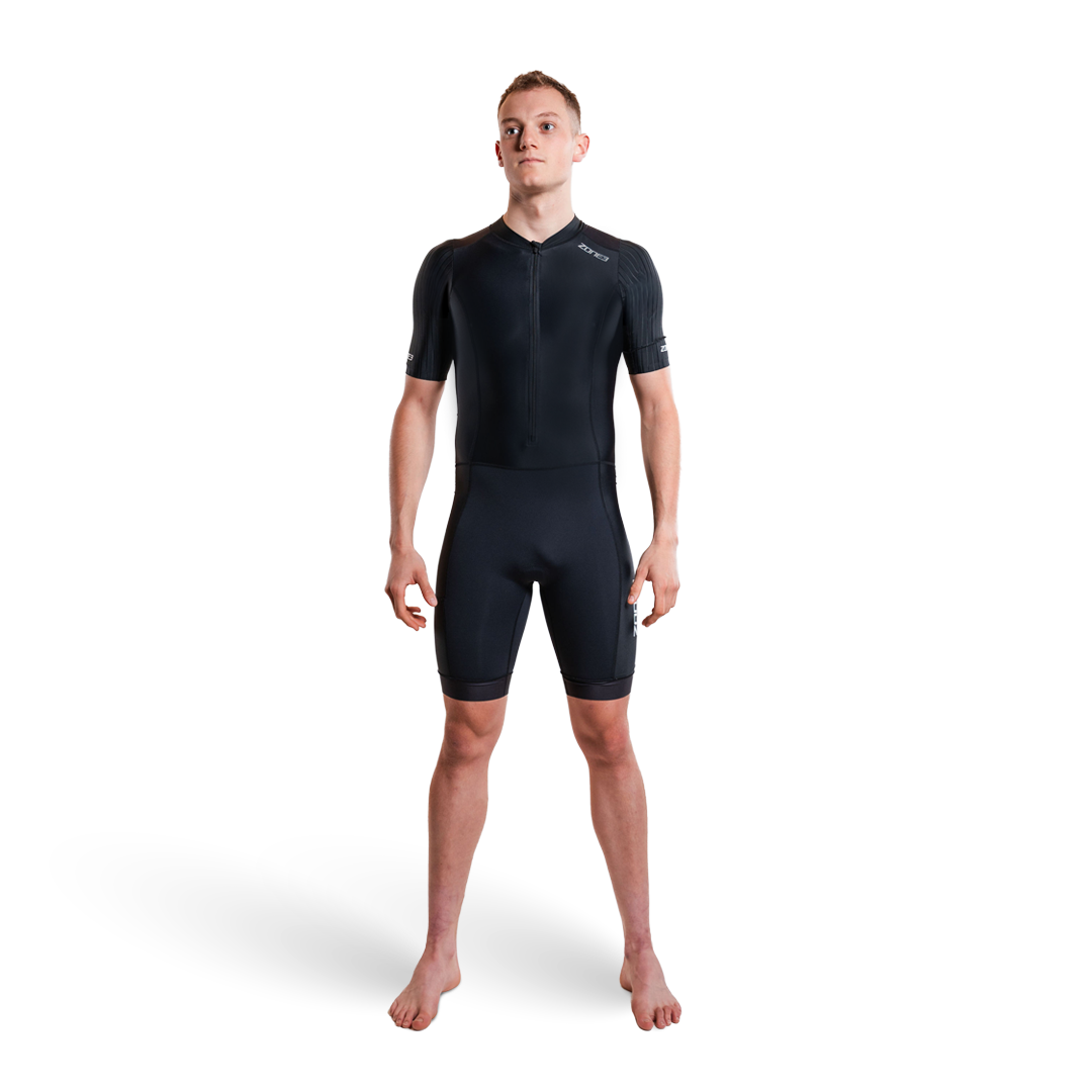 Person trägt einen schwarzen Trisuit auf weißem Hintergrund
