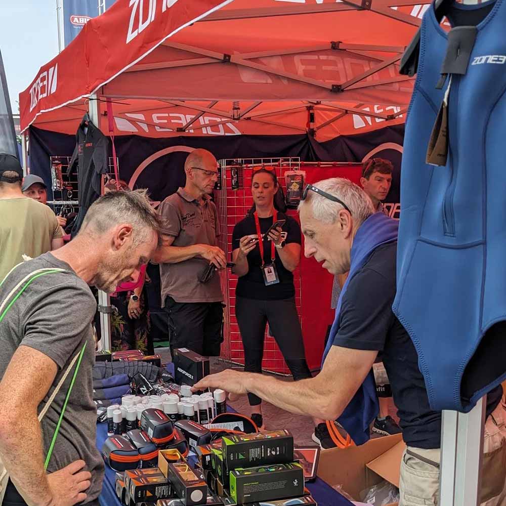 ZONE3 attending the challenge Roth event in 2023. Image depicts multiple people in conversation surrounded by ZONE3 products and a ZONE3 tent.