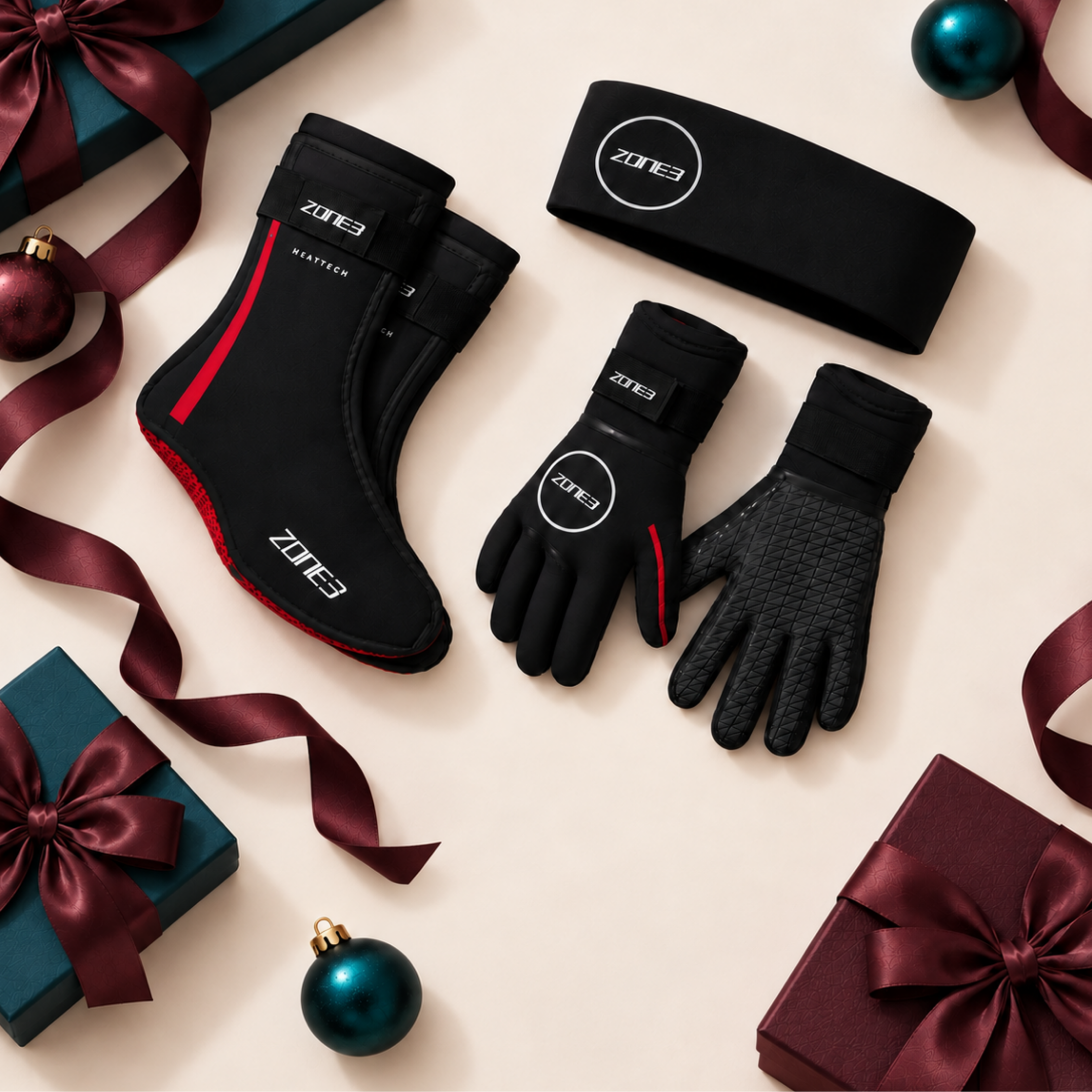 A set of black Zone 3 athletic gear including gloves, socks, and a sleeve, displayed on a clean light gray background. The products feature white branding, red accents on the socks and gloves, and a green Zone 3 logo patch.