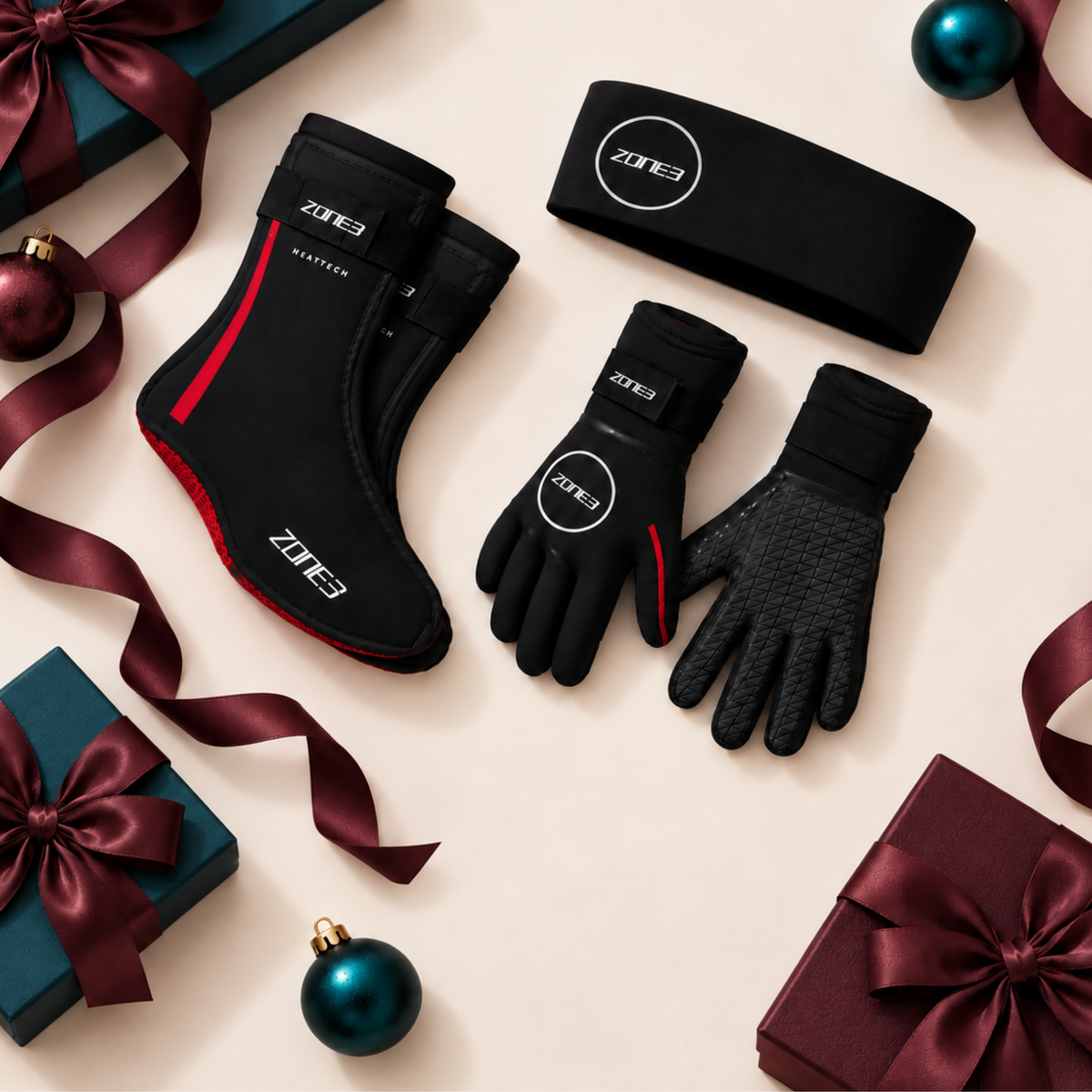 A set of black Zone 3 athletic gear including gloves, socks, and a sleeve, displayed on a clean light gray background. The products feature white branding, red accents on the socks and gloves, and a green Zone 3 logo patch.