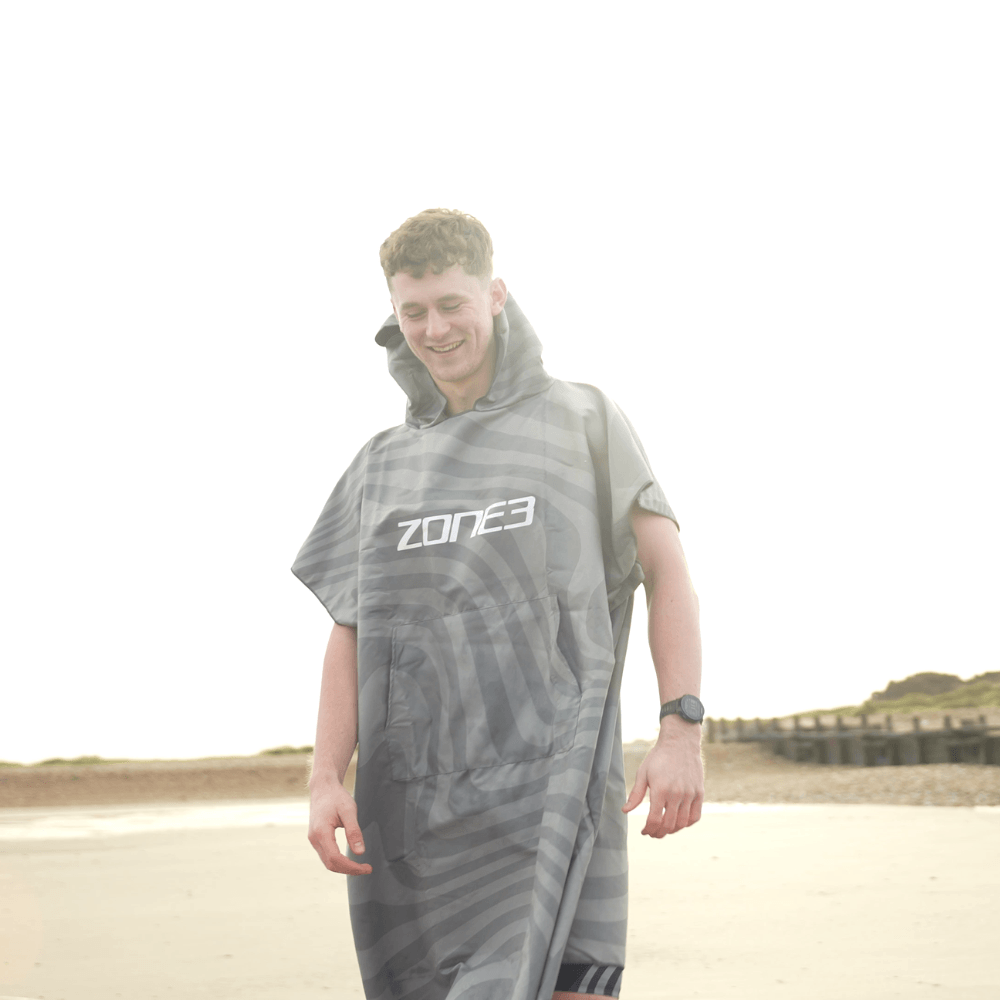 athlete wearing Zone3 changing robe with print at the beach. 