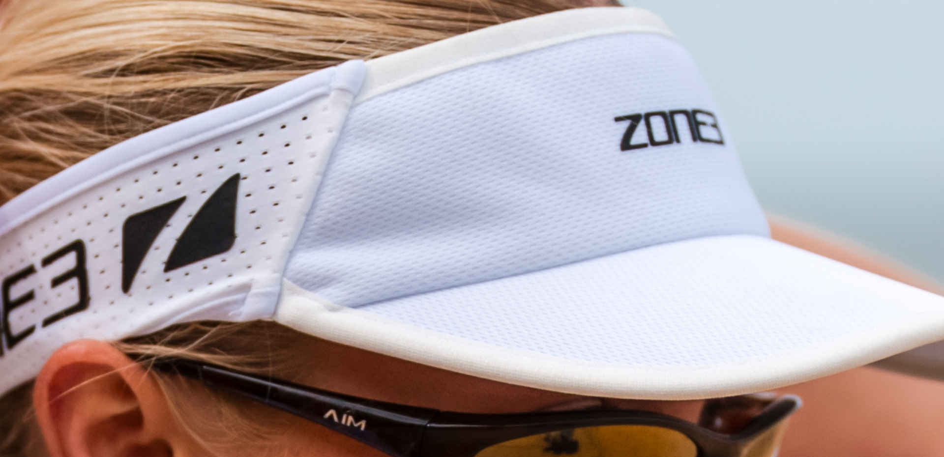 Close up of zone3 white running visor with a zone3 logo on a blurred background